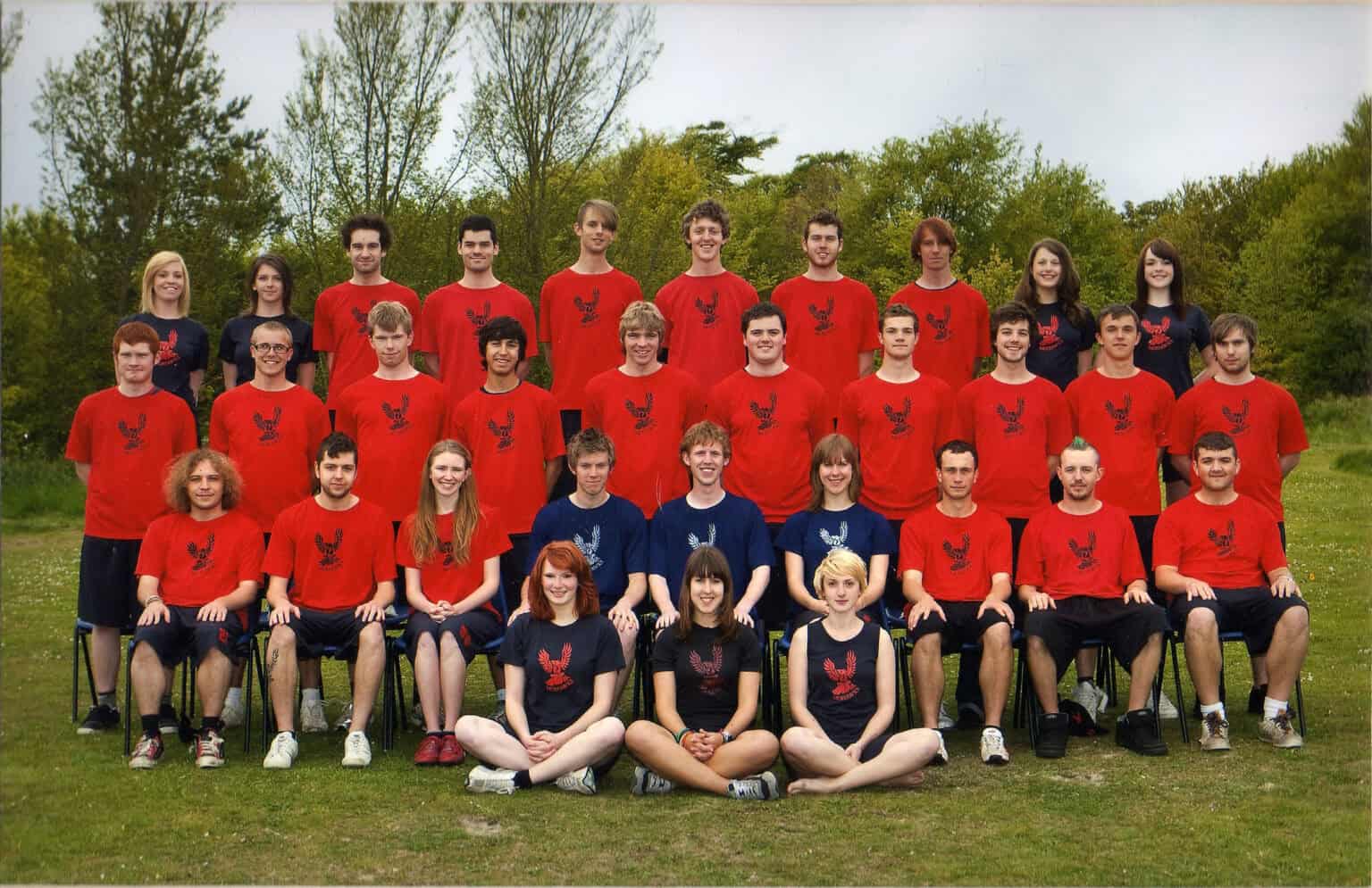 Group of young athletes wearing Mohawks Ultimate team T-shirts, outdoor team photo in a lush green park, showcasing team spirit and unity.