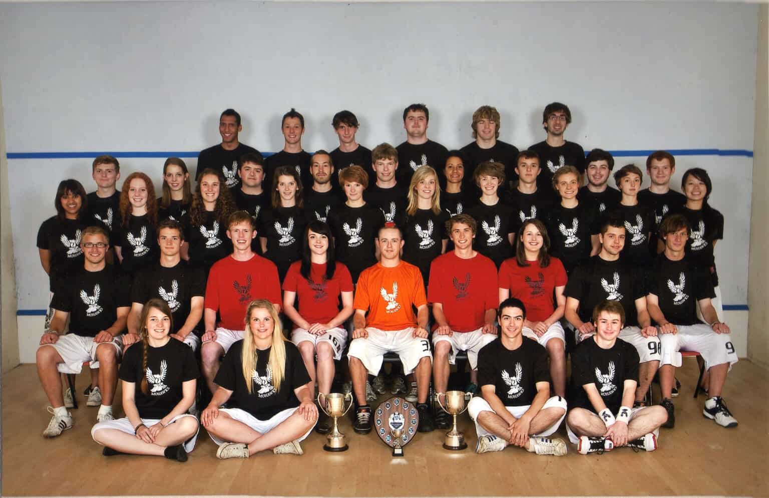 Team of Mohawks Ultimate Frisbee players in matching black and red team shirts, posing with trophies.