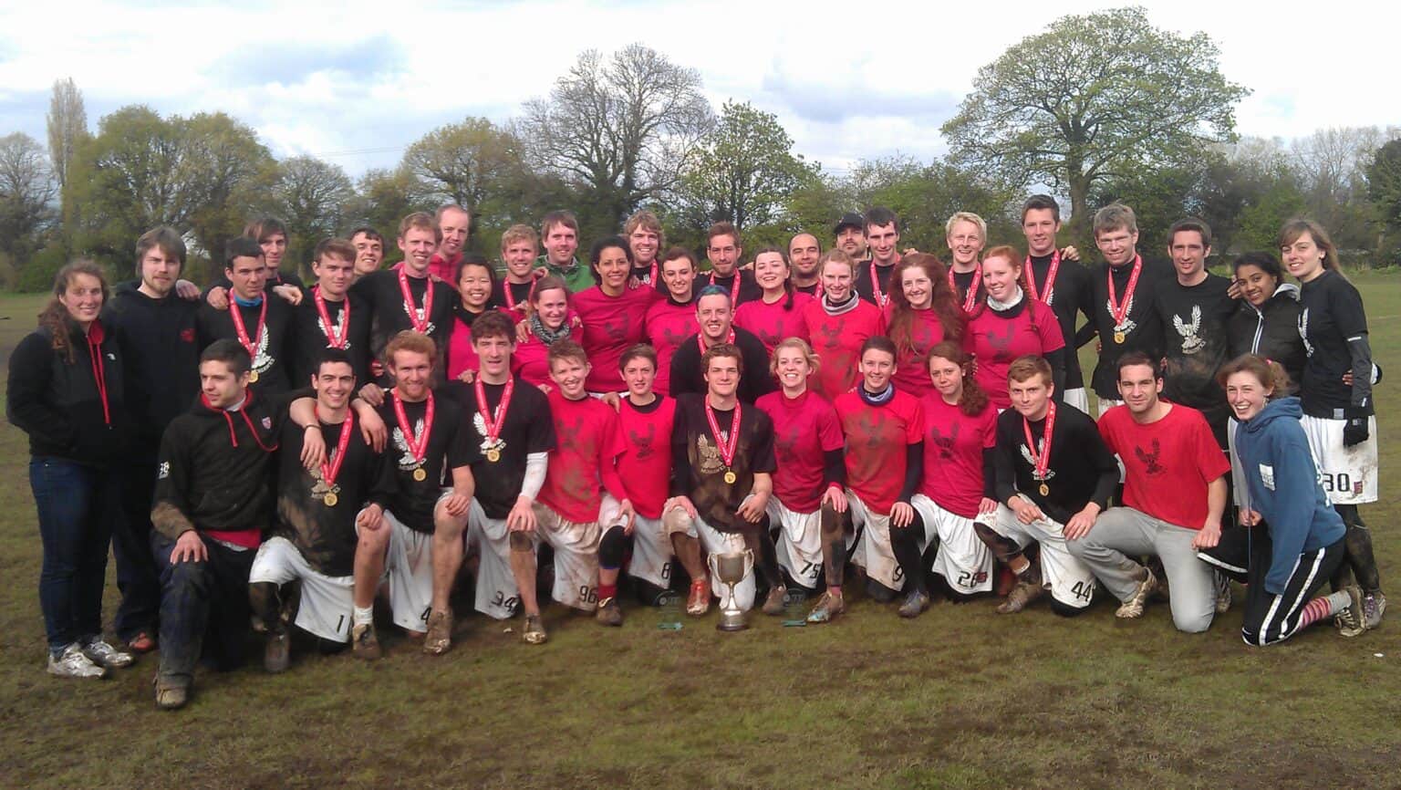 Victorious mohawks rugby team celebrating win with medals and trophy.